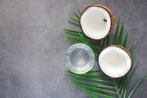Slice of fresh coconut and glass of coconut water on table