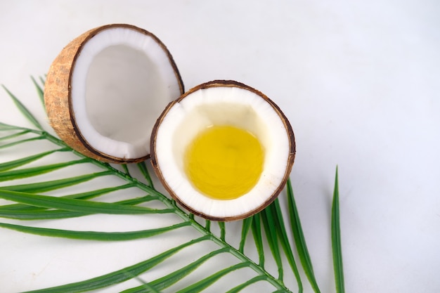 Slice of fresh coconut and oil on white background with copy space