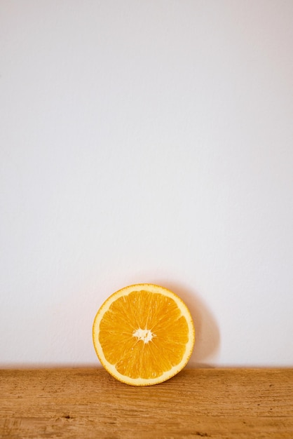 Slice of fresh organic orange on a wooden cutting board.