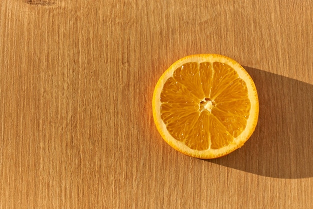 A slice of fresh organic orange on a wooden kitchen counter