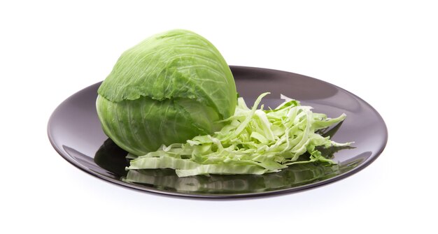 白い背景で隔離の皿に緑のキャベツをスライスします。