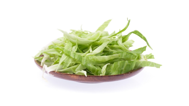 Slice green cabbage on a wood plate isolated on white background