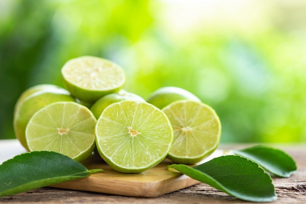 Slice green fresh lemon on wooden table background