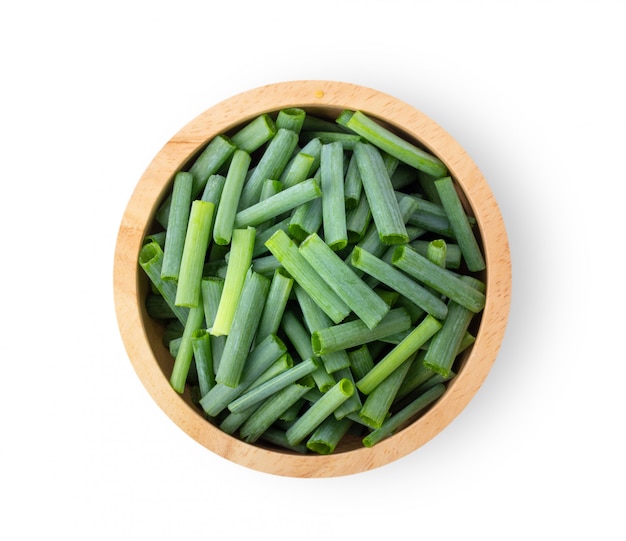 Slice green onions in wood bowl