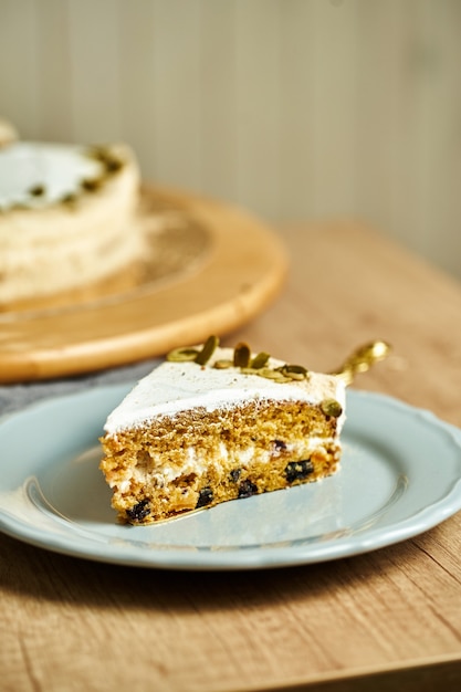 Slice of homemade Carrot cake on plate. Wooden background