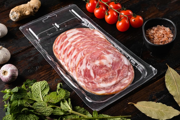 Slice of Italian ham and meat  in vacuum package set, on old dark  wooden table background