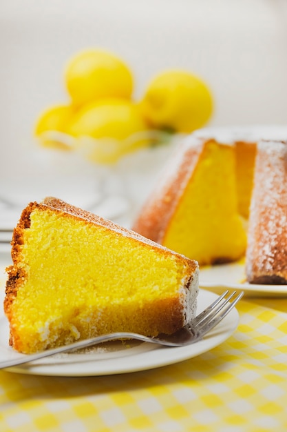 A slice of lemon cake with lemons