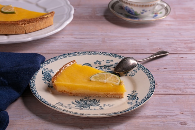 Slice of lemon pie on an old plate on a wooden table