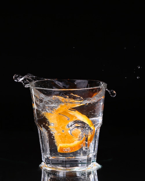 Photo slice of lemon splashing into a glass of water