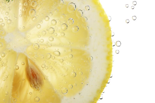 Photo slice of lemon in the water with bubbles isolated on white