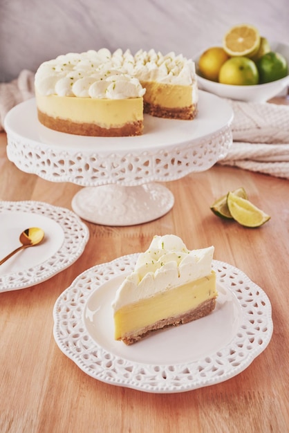 A slice of lime pie sits on a white plate next to a lime slice.