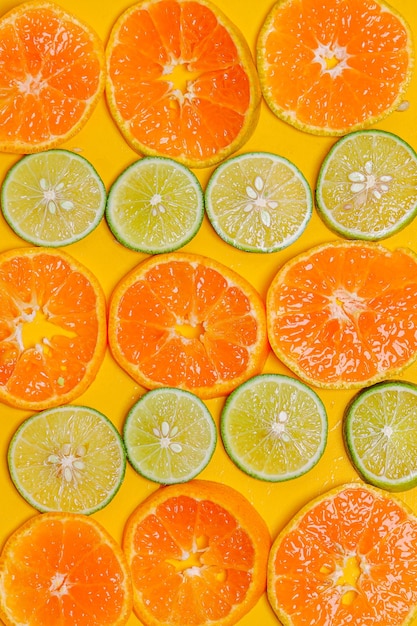 노란색 배경에 배열된 오렌지 과일 라임 감귤 조각