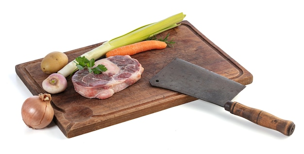 Slice of raw beef shank and vegetables on a cutting board