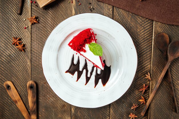 초콜릿 소스로 장식 된 빨간 벨벳 케이크 조각