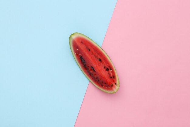 Slice of ripe watermelon against pink blue background. Top view. Minimalism