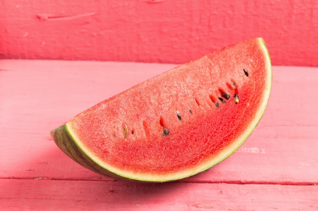 slice of ripe watermelon on wood pink