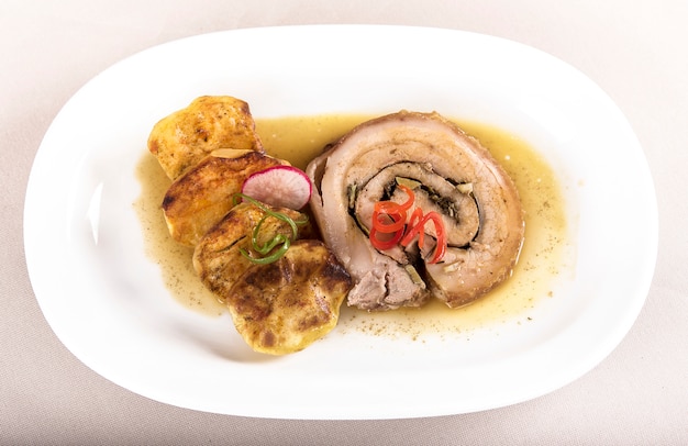 Slice roasted pork, served with potatoes and decorated with herbs