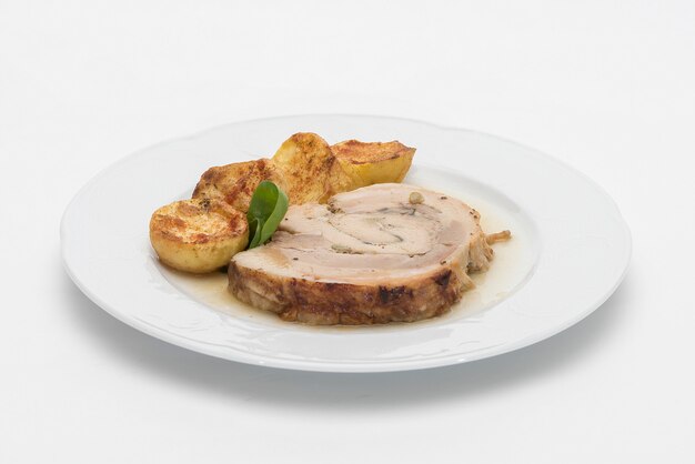 Slice roasted pork, served with potatoes and decorated with herbs