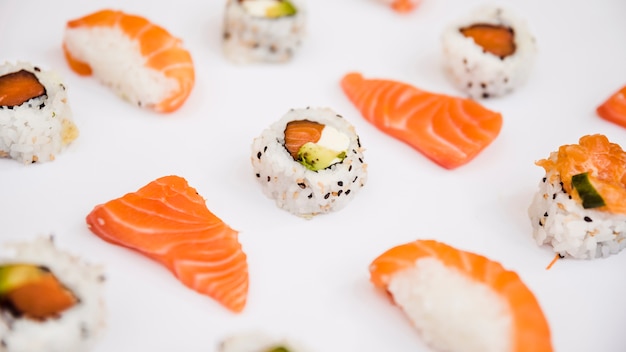 Foto fetta di salmone e sushi isolato su sfondo bianco