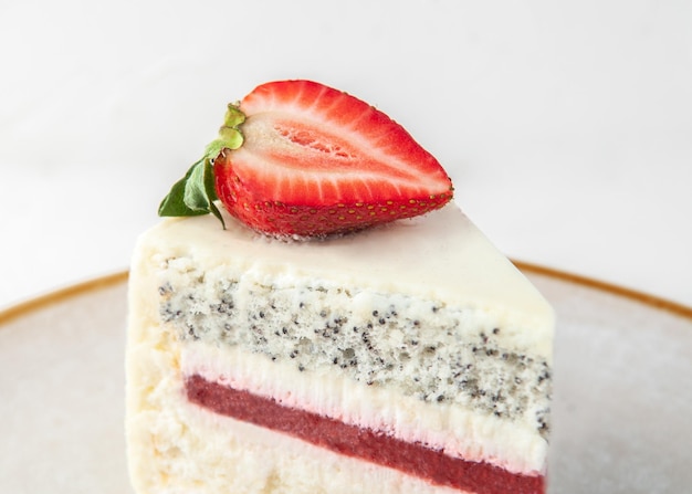 a slice of strawberry cake on a gray plate decorated with strawberries closeup on a white background