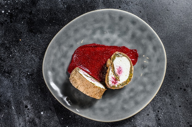 Slice of Swiss roll with strawberry jam and cream