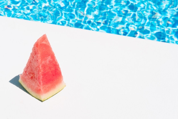 Кусочек арбуза у бассейна концепция летнего отдыха и еды