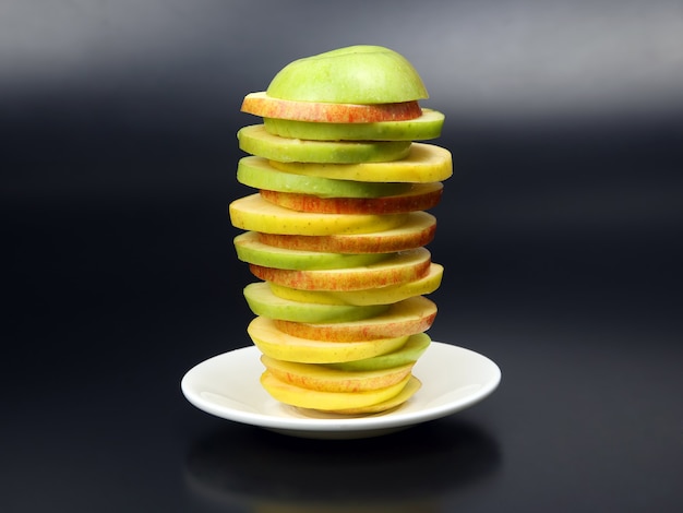 Sliced ââapple in a pyramid on a white plate