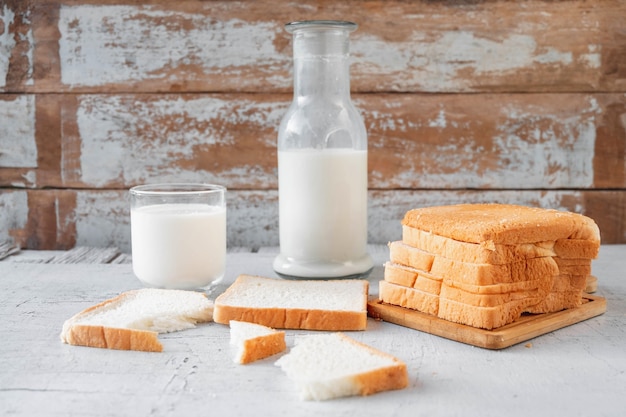 Sliced ââbread with a glass of milk and a bottle of fresh milk