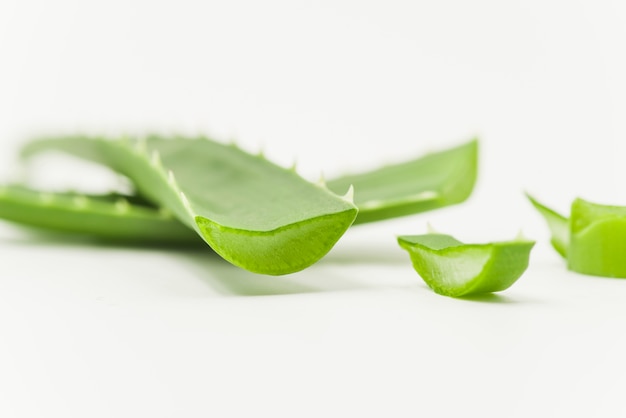 Foto cosmetici naturali di rinnovamento organici aloevera affettati su fondo bianco