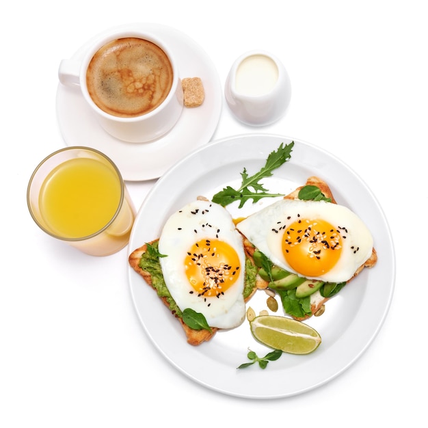 Sliced avocado and fried egg on toasted bread isolated on white background