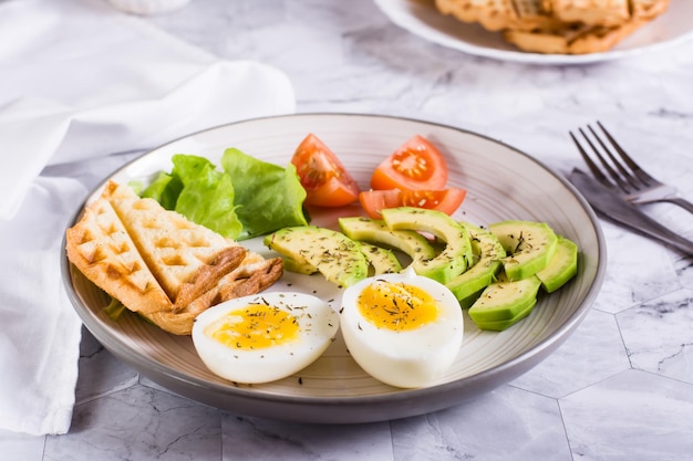 얇게 썬 아보카도 부드러운 삶은 계란 토마토와 접시에 토스트 홈메이드 아침 식사