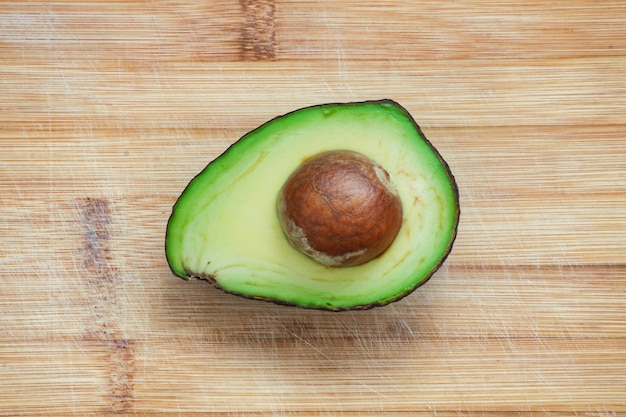 Sliced avocado on wooden background. Top view on ripe avocado.