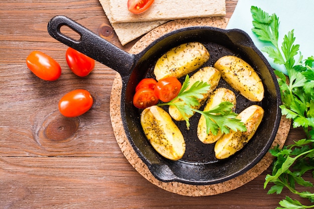 Sliced baked potatoes in an iron frying pan