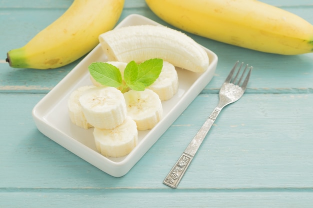 Sliced banana on bowl on a blue wooden the floor.