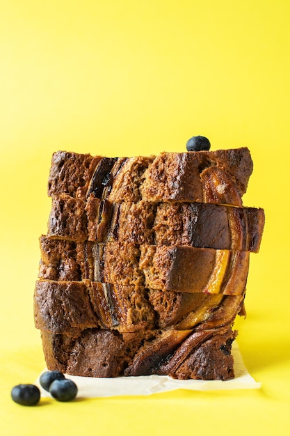 Photo sliced banana bread with blueberries on yellow background