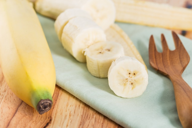 Photo sliced banana on a green cloth