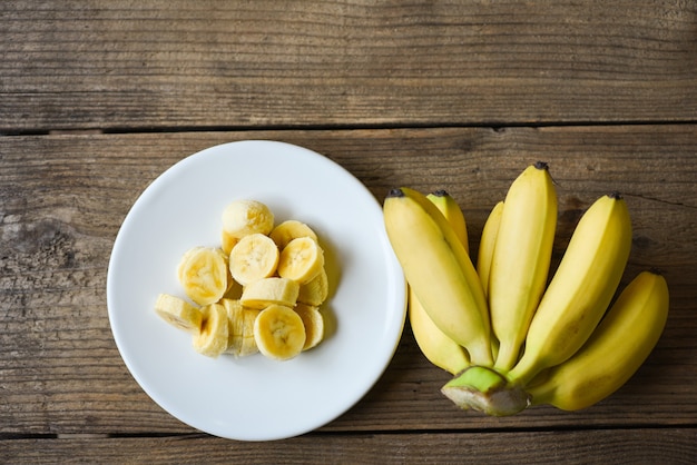 Sliced banana peel on white plate and wooden background, Peeled banana ready to eat