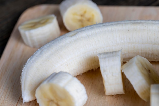 Sliced banana on a wooden table while cooking fresh banana cut into several pieces