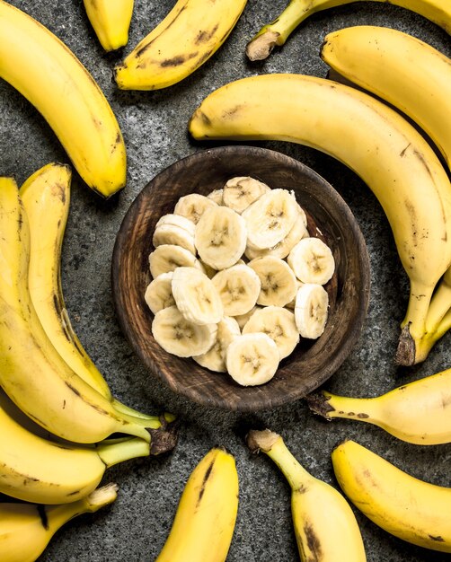 Sliced bananas in a bowl on a rustic background