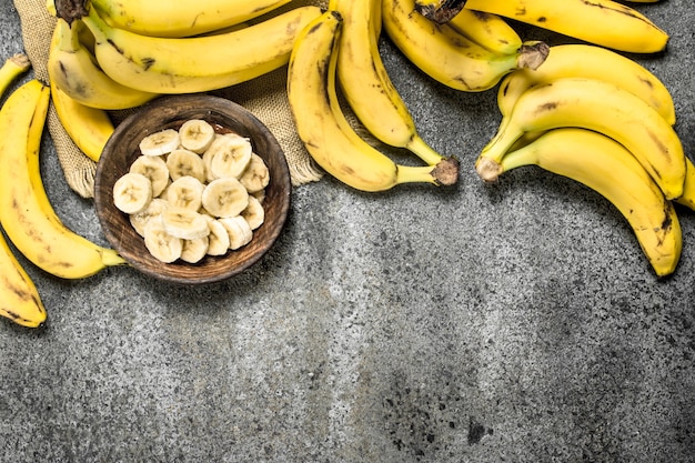 Sliced bananas in a bowl on rustic table.