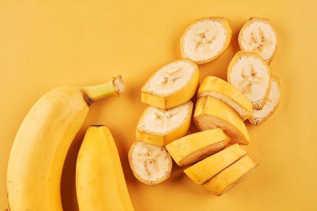 Sliced bananas on yellow surface