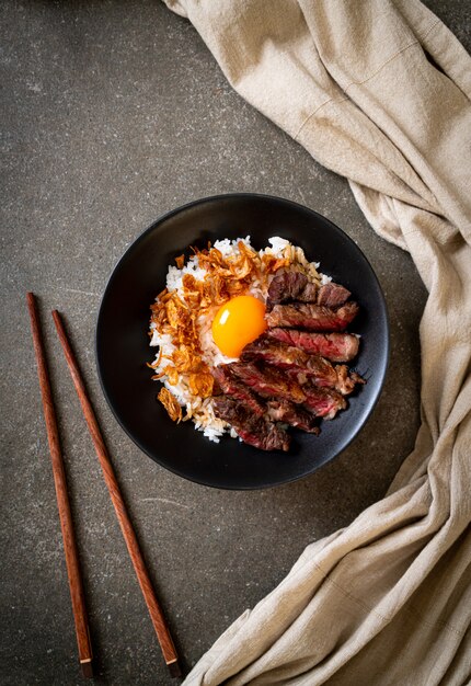 Фото Нарезанная говядина на рисовой миске с яйцом