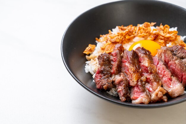 sliced beef on topped rice bowl with egg