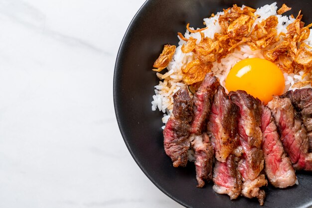 sliced beef on topped rice bowl with egg