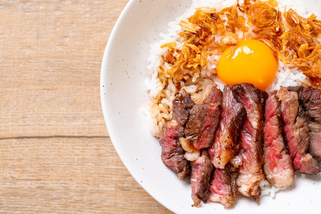 sliced beef on topped rice bowl with egg