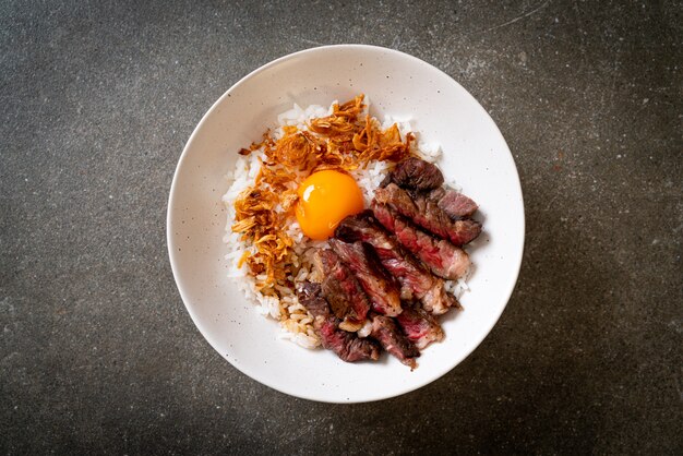 sliced beef on topped rice bowl with egg