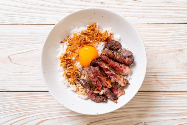 sliced beef on topped rice bowl with egg