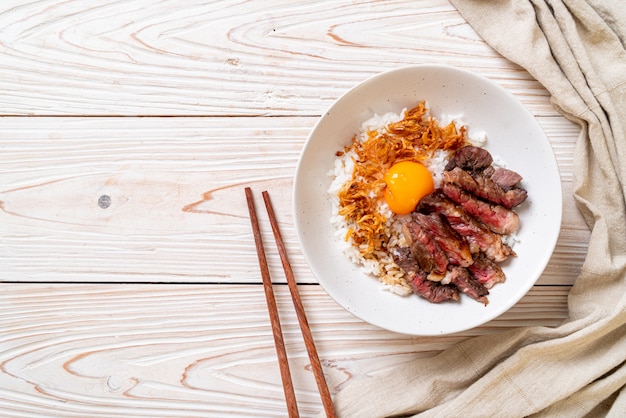 sliced beef on topped rice bowl with egg