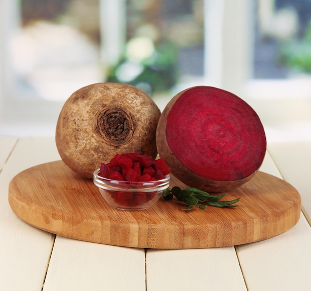 Sliced beetroot on board on wooden table on window background