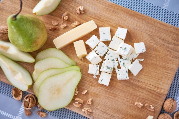 Sliced Blue cheese pears and walnuts on wooden board